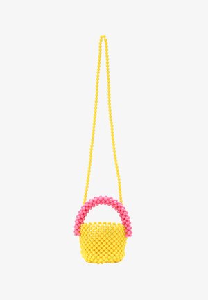 Sárga gyöngyökkel díszített kézitáska rózsaszín, ívelt fogantyúval, lekerekített formával és texturált felülettel, hosszú sárga pánttal felfüggesztve.