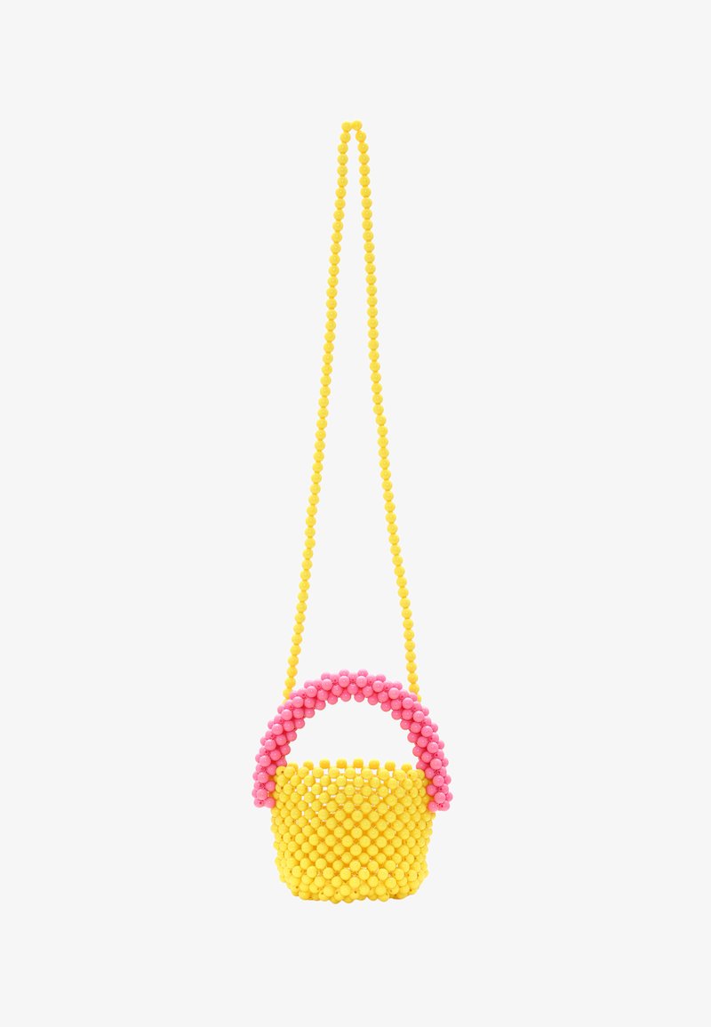 Sárga gyöngyökkel díszített kézitáska rózsaszín, ívelt fogantyúval, lekerekített formával és texturált felülettel, hosszú sárga pánttal felfüggesztve.