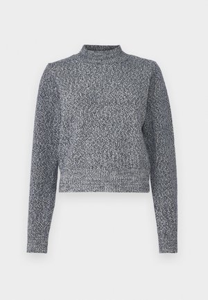 Sinih ja valge kudum, millel on kõrge kaelus, pikad varrukad ja lühike lõige; sisaldab tekstuurset, täpilist disaini.