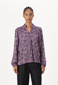 Blusa floreale viola con scollatura arricciata, maniche lunghe e vestibilità comoda; il tessuto presenta un motivo di piccoli fiori e swirl.