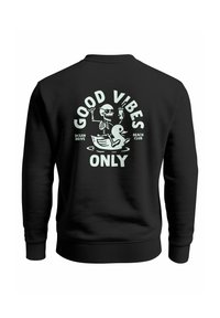 Schwarzer Pullover mit einem grafischen Design eines Skeletts, das Getränke auf einem Gummienten hat, begleitet von "NUR GUTE VIBES" in weißem Text.
