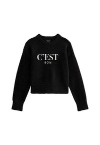 Pull court noir avec une texture douce et duveteuse. Présente un texte imprimé blanc « C’EST BON » sur le devant. Encolure ras du cou et manches longues.