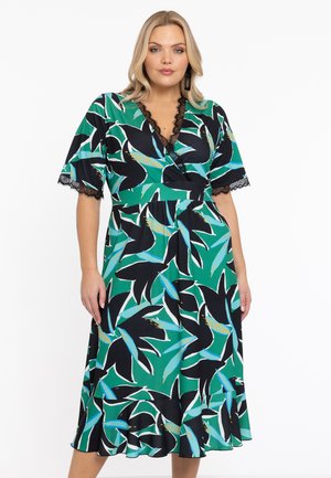 Wikkeljurk in zwart, groen en blauw met bloemenpatroon. Heeft korte mouwen en kantafwerking bij de halslijn. Uitlopende zoom. Zachte stofstructuur.