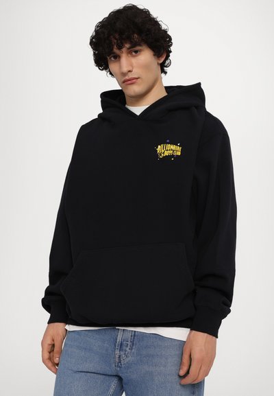 Hoodie noir en mélange de coton, avec une poche kangourou, une capuche à cordons et un logo jaune subtil sur la poitrine. Design simple.