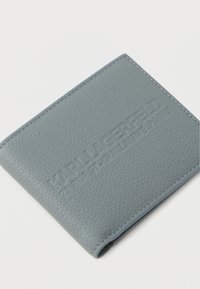 Jasnoniebieski portfel z teksturowanej skóry z wytłoczonym na froncie logo "KARL LAGERFELD 21 RUE ST-GUILLAUME PARIS".