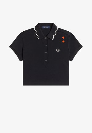 Polo noir à manches courtes avec bord de col ondulé blanc, patte de boutonnage, deux écussons en forme de cœur rouge et petit logo laurier blanc sur la poitrine.