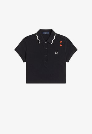 Camiseta polo negra de manga corta con borde del cuello ondulado blanco, tapeta de botones, dos parches de corazón rojo y pequeño logo de laurel blanco en el pecho.