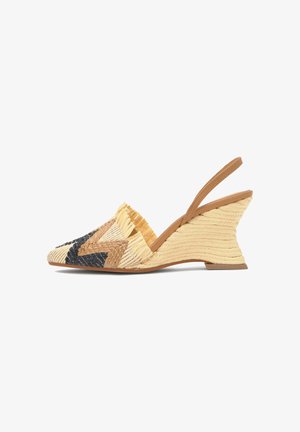 Zapato con cuña y tiras traseras tejido en beige, marrón claro y negro con detalles de flecos a lo largo del borde delantero.
