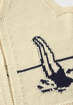 Beige knitted fabric with black and white patterned design resembling a hand reaching across a horizontal line.