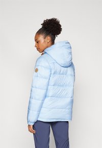 Giacca a vento azzurro chiaro con cappuccio, design trapuntato, polsini elasticizzati e toppa con logo sulla manica sinistra. Texture liscia e lucida.