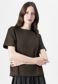 Brown short-sleeve t-shirt with a round neckline and soft texture. Features a relaxed fit and simple stitching details at the hem.