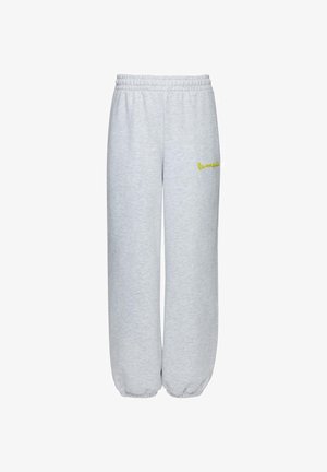 Helehallid dressipüksid elastse vöökohaga ja mansettidega, millel on vasakul reiel väike kollane tikitud logo.