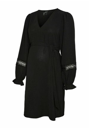 Robe de maternité noire avec décolleté en V, manches longues bouffantes, accents en dentelle sur les poignets et une taille nouée, faite en tissu léger.