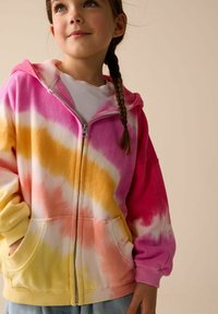 Felpa con cappuccio e zip caratterizzata da un motivo tie-dye nei toni del rosa, arancione e giallo. Tessuto morbido con tasca frontale e polsini a costine.