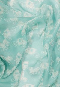 Svetlo modra tkanina z ponavljajočim se vzorcem belih kočij, prikazana z mehkimi gubami in kretnjami.