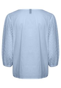Blouse bleu clair avec un dos uni, des manches en œillets texturés avec un motif en zigzag et un col rond.
