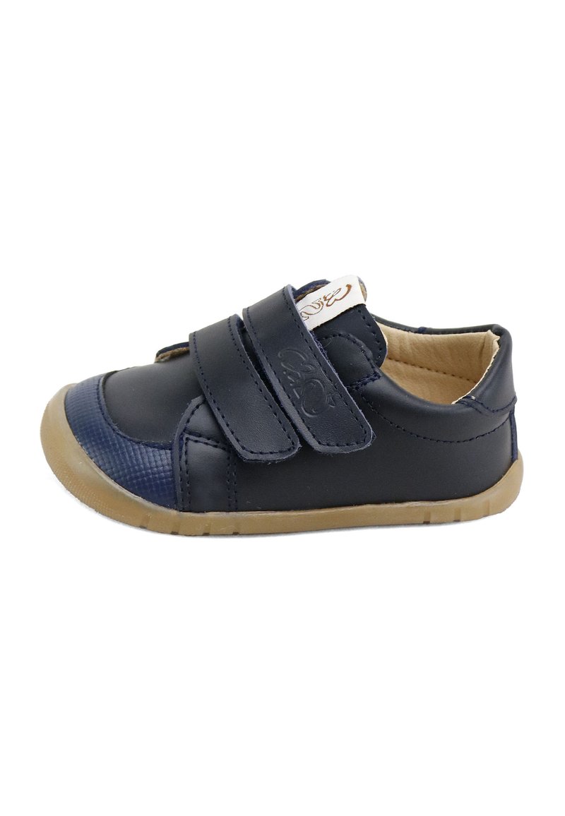 Zapato para niño pequeño de color azul marino con dos correas de velcro, forro interior beige, puntera texturizada y suela de goma flexible marrón claro.