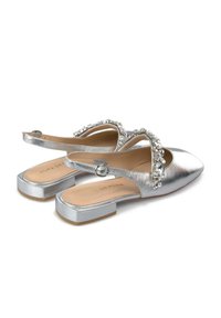 Ballerine slingback argento con punta appuntita, decorate con strass lungo la fascia e tacco basso a blocco. Texture metallica liscia.