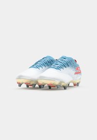Chaussures de football blanches avec des accents bleu clair, tige texturée et un design dégradé. Présente des crampons multicolores pour une meilleure adhérence.