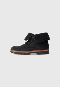Botas de cuero negro con un collar de pelo negro deshilachado, que presentan cordones redondos, un acabado texturizado y una suela de goma con un patrón de tread definido.