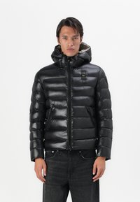 Schwarze Pufferjacke mit glänzender Oberfläche, Kapuze, Reißverschluss und Seitentaschen. Verfügt über ein abgestepptes Design mit horizontalen Streifen.
