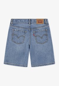 Jasnoniebieskie szorty dżinsowe o prostym kroju. Posiadają dwie tylne kieszenie z zaokrąglonymi szwami, żółte przeszycia oraz brązową metkę marki.