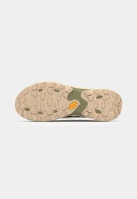 Outsole of a shoe featuring a textured rubber surface in beige with a green midsole. Prominent tread design for traction.