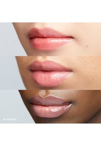 Drie sets lippen in variërende nude tinten: bovenaan is een zachte roze, in het midden een matte beige, onderaan een glanzend bruin met een gladde textuur.