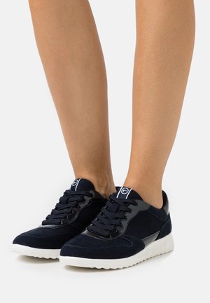 Sneakers in camoscio blu navy con suola in gomma, dotate di lacci rotondi, dettagli in pelle e un particolare lucido sul tallone.