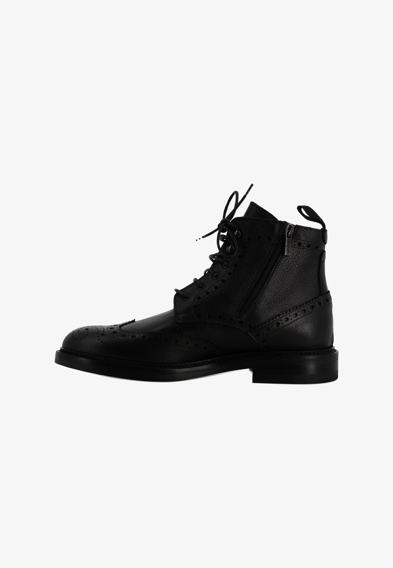 Stivaletto alla caviglia in pelle nera con dettagli brogue, punta rotonda, chiusura con lacci, cerniera laterale e suola piatta. La finitura testurizzata aggiunge profondità.