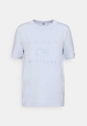 Jasnoniebieska koszulka z krótkim rękawem i okrągłym dekoltem z napisem "TOMMY HILFIGER" i logo wyszywanymi na przodzie w pasującym niebieskim kolorze.