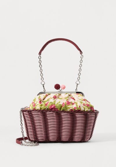 Geantă țesută cu o bază roz, capac din material cu un model floral și un strap din lanț. Are accente rotunde decorative pe închizătoare.