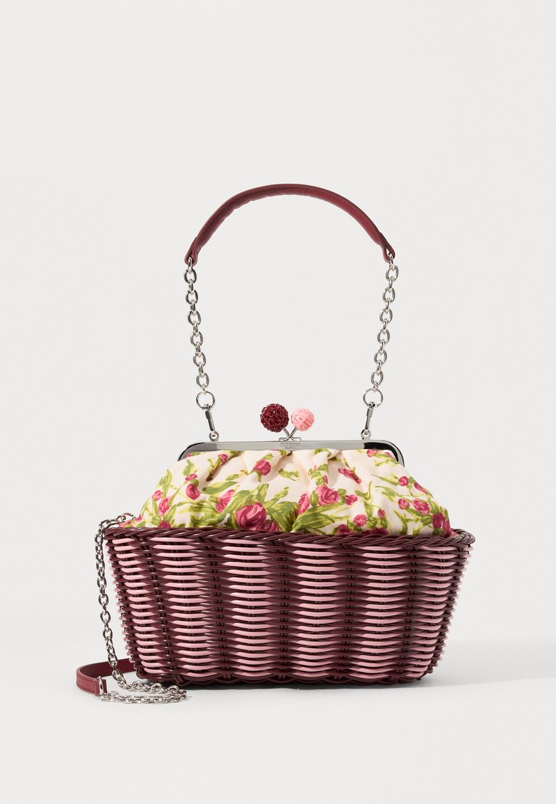 Woven handbag with a pink base, floral patterned fabric top, and a chain strap. Features decorative round accents on the clasp.