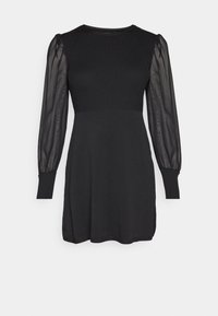 Robe noire avec un corsage côtelé et des manches longues transparentes, dotée d'un col rond et d'une coupe décontractée, avec des fentes sur les côtés à l'ourlet.