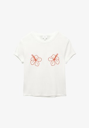 Valkoinen lyhythihainen t-paita, jossa on edessä kaksi oranssia brodeerattua hibiskusta. Pehmeää kangasta, rento istuvuus ja pyöreä kaula-aukko.