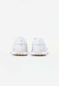 Scarpe da ginnastica bianche in rete con accenti grigi, un pannello testurizzato e una suola ammortizzata, caratterizzate da un design a profilo basso e un dettaglio del logo sul retro.
