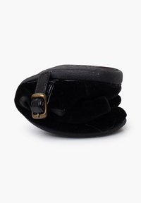 Bolsa de terciopelo negro con forma redondeada y acabado texturizado. Presenta un pequeño broche en tono dorado y una correa negra para el cierre.