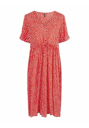 Robe rouge mi-longue avec des taches abstraites blanches, manches courtes, col en V, boutonnée à l'avant, et taille froncée avec un cordon de serrage.