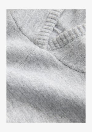 Szürke kötött pulóveranyag közeli felvétel, V-nyakkivágással, bordázott textúrával és puha, sima gyapjúkeverék felülettel.