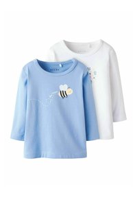 Dwie długie koszulki dla małych dzieci, jedna jasnoniebieska z uśmiechniętym pszczółkiem i napisem "Bądź szczęśliwy", druga biała z małym wzorem kwiatowym.