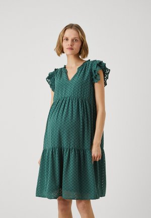 Grünes, strukturiertes Kleid mit V-Ausschnitt, Rüschensleeves und einem gestuften Saum. Hat ein geometrisches Muster auf der gesamten Fläche. Leichter Stoff.