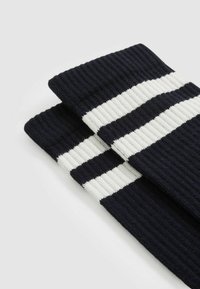 Marineblaue gerippte Socken mit zwei weißen horizontalen Streifen. Das Material hat eine weiche Textur und das Design umfasst einen umgeschlagenen Bund.