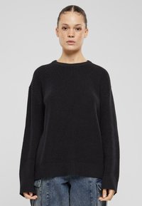 Schwarzer gestrickter Pullover mit gerippter Textur, breiten Bündchen und rundem Ausschnitt. Verfügt über eine lockere Passform und ein Design mit fallenden Schultern.