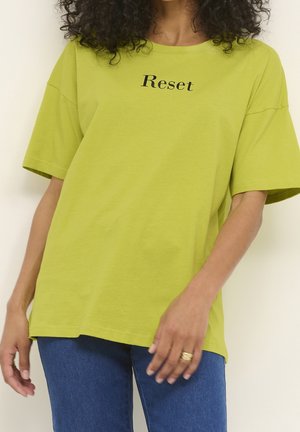 Zielona, oversize'owa koszulka z bawełny, z napisem "Reset" w czarnym kolorze na klatce piersiowej. Krótkie rękawy i luźny krój.