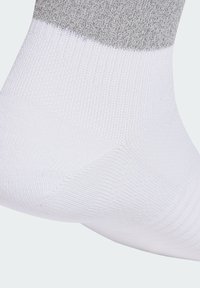 White and gray knitted sock with a contrasting gray band near the top, featuring a smooth, breathable texture and ribbed design.