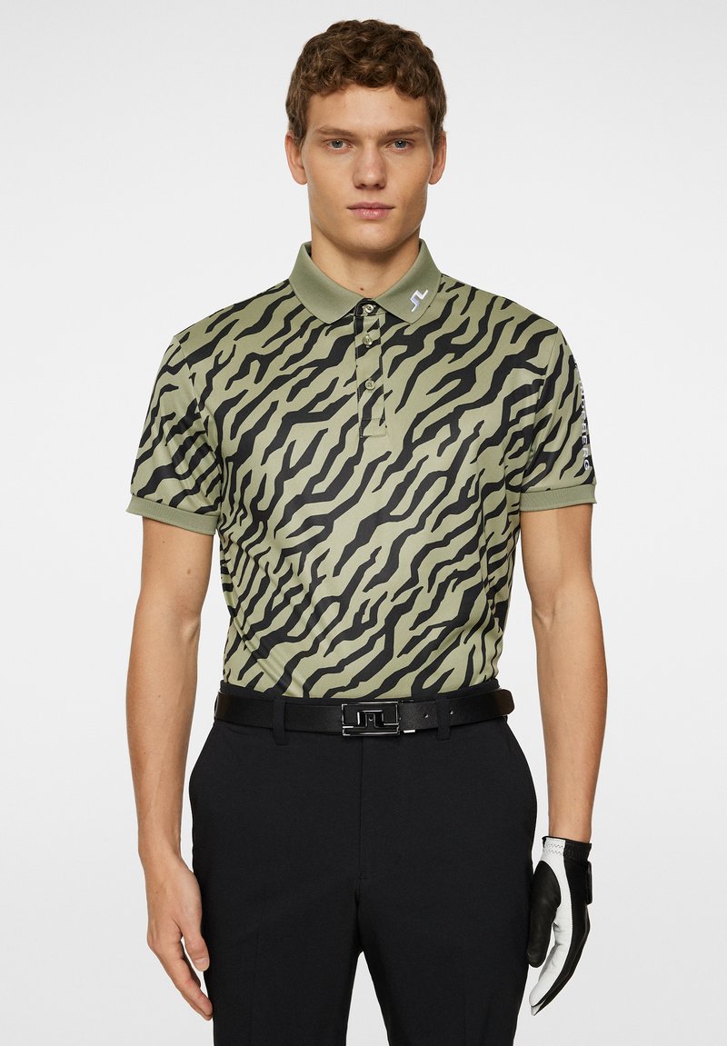 Kortärmad pikétröja i olivgrön med svarta tigerstripor, med krage, fyra knappar och broderad logotyp på bröstet.