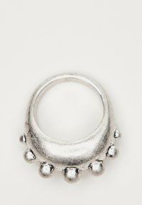 Anello d'argento con una fascia liscia, caratterizzato da accenti a bulbo arrotondati lungo il bordo. La superficie ha una finitura metallica lucida.