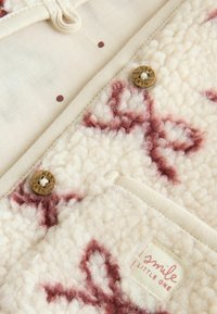 Fleecejacke in Creme mit kastanienbraunen Mustern. Verfügt über große Knöpfe mit der Aufschrift "NEXT", ein gewebtes Etikett und eine strukturierte Oberfläche.