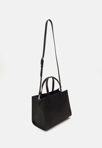 Melnas ādas roka soma ar noņemamu plecu siksnu, strukturēta forma, divas rokturi un smalka tekstūra. Sudraba toņu piederumu akcenti.