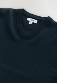 Marineblaues V-Ausschnitt-Pullover aus weichem Material, mit ribbeltem Ausschnitt und Saum. LABEL: NEXT, Größe M. Einfache Gestaltung, nahtlose Verarbeitung.